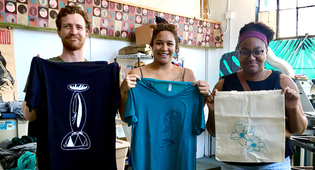 3 friends holding the screenprinted works